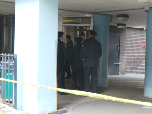 Police stand outside the entrance to the Fulton Houses on Dec. 12, 2011.