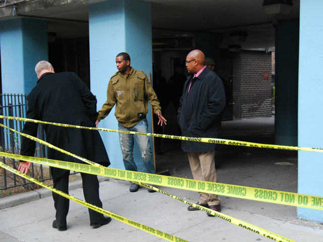 NYPD detectives question a friend of a victim in a murder-suicide on Dec. 12, 2011.