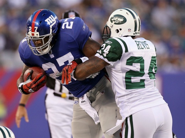 The Giants' Brandon Jacobs runs the ball against the Jets' Darrelle Revis during their preseason game on Aug. 29, 2011.
