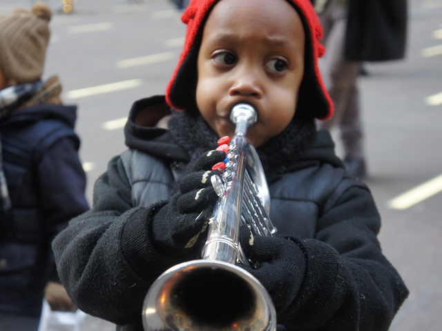 Little Aidan Ortiz, 5, plays the trumpet at Occupy Christmas
