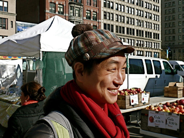 Christina C. in a jaunty tartan cap with pompom in the Union Square Farmers Market.