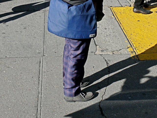 Very tailored purple tartan with a Jack Spade nylon jacket and gray Chukka boots on a female pedestrian on 14th Street, West Village.