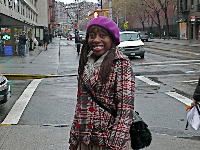 Deona G. in a red black and gray houndstooth pea coat with contrasting accessories, in the West Village.