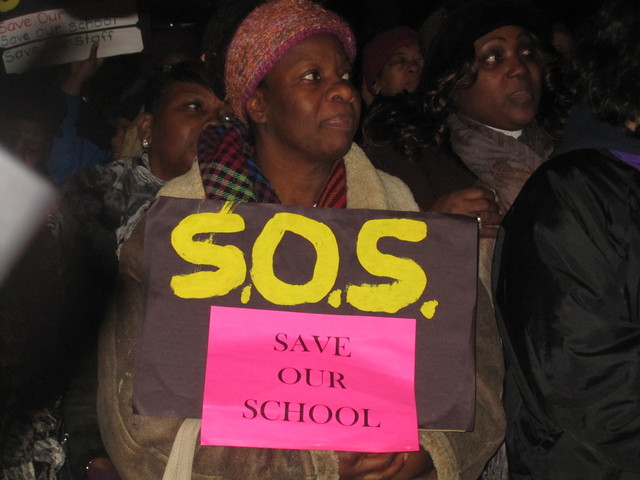 A protester holds up a sign asking the DOE to 