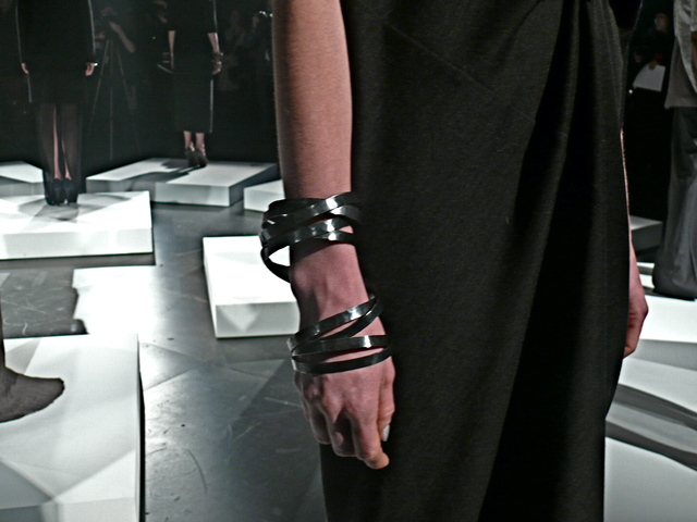 A detail of Sofie in gray wool cashmere bias cut dress and modern stacked bands by Castro for Brandon Sun.