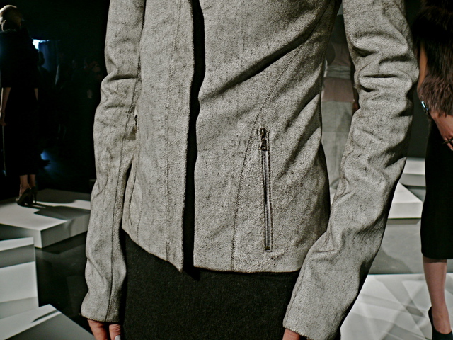 Detail of Kaytya's blizzard cracked leather jacket with utility zipper pocket.