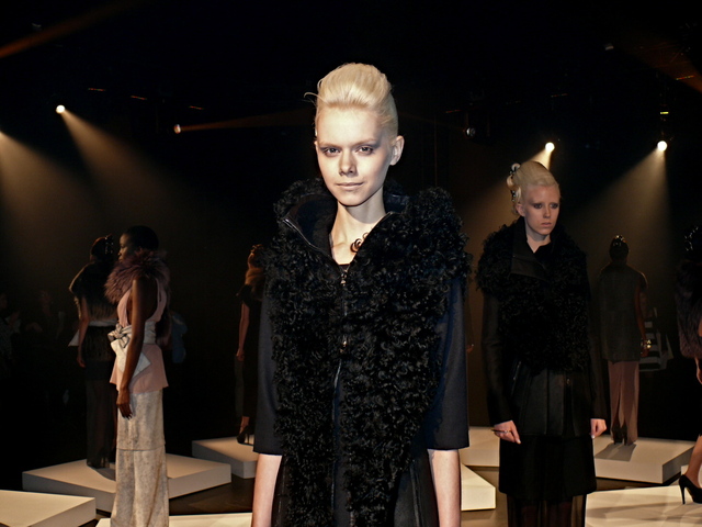 Kersti in black monochrome shearling hooded vest, black crepe gabardine and cashmere knitted dress.