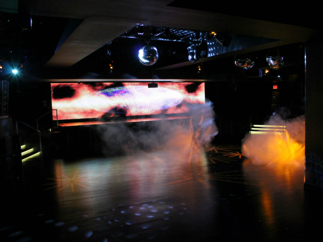 The main dance floor of XL, complete with smoke machines, disco balls, and a massive LED screen.