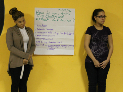 Cheyenne Lee, 18, and Mireya Ruiz, 17, presented a poster during a community meeting on Feb. 16, 2012, which listed their concerns with a city plan to move a new charter school into their high school building.