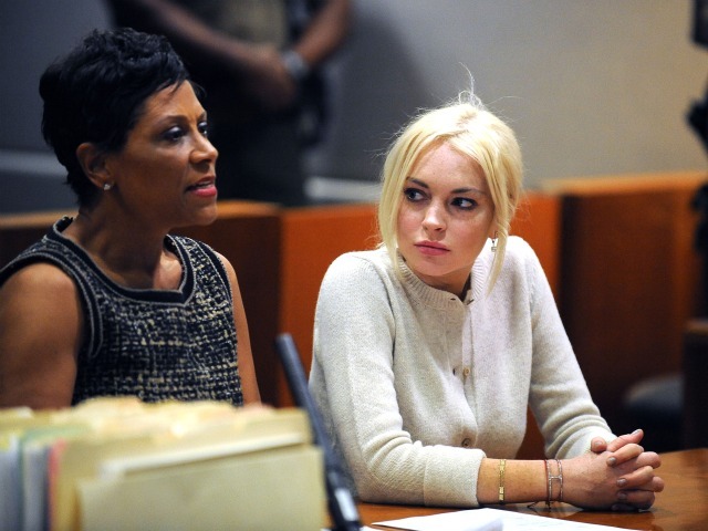 Shawn Chapman Holley, Lohan's attorney, (L) Lindsay Lohan sits in court during her probation report hearing at the Airport Courthouse on December 14, 2011 in Los Angeles, California. According to Judge Stephanie Sautner, Lohan is successfully meeting the conditions of her probation. Lohan is currently performing 480 hours of community service at the Los Angeles County Coroner's office and attending court ordered psychotherapy sessions stemming from a 2007 drunk-driving conviction and a jewelry theft conviction earlier this year. 