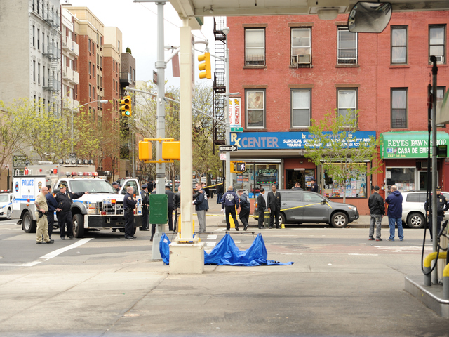 The blue tarp marks the spot where the suspect was shot on April 12, 2012 as he fled the pharmacy on First Avenue. 