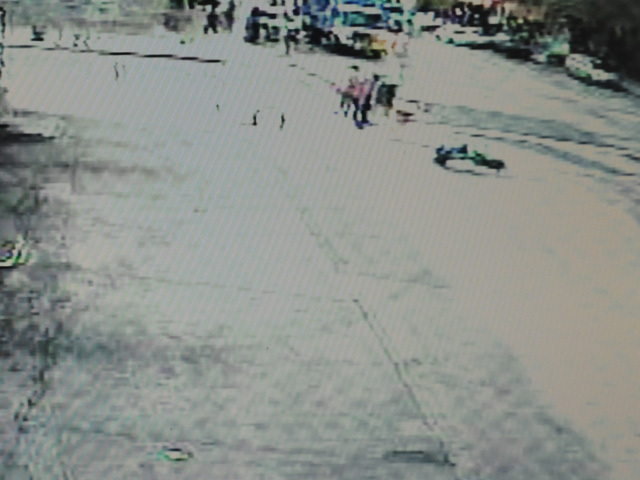 A still from the surveillance video at the gas station shows the robbery suspect falling in the upper right corner after a retired lieutenant fired a shot. 
