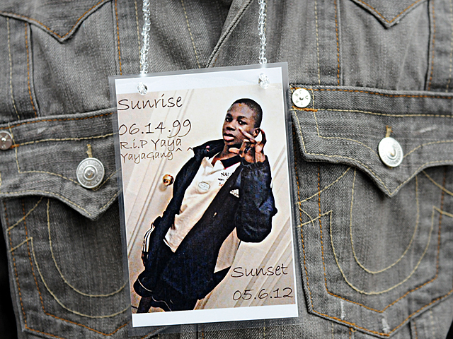 A friend of Yakim McDaniels wears a photo of the 12-year-old during a vigil on May 7, 2012. 