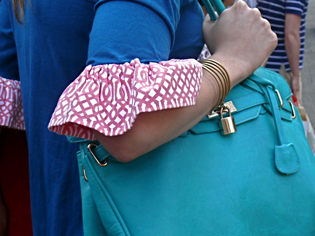 Cool shades of blue in a knit sheath dress with a contrasting ruffle and an aqua bag on Fifth Avenue in Midtown.