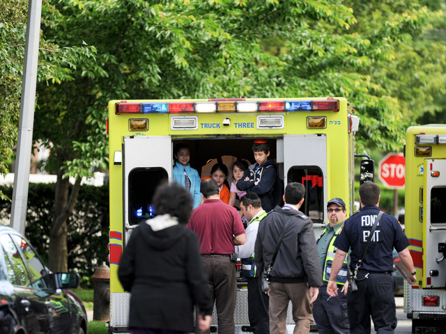<p>Paramedics check out children from the school bus crash on Tuesday June 5, 2012.</p>
