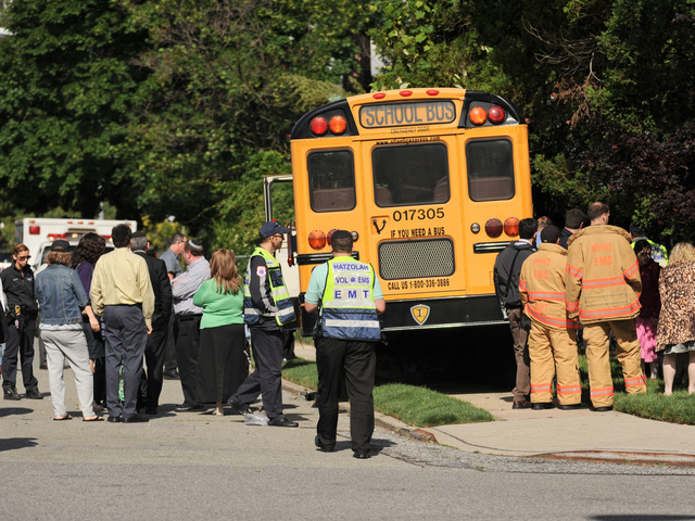 <p>Emergency workers and parents gather around the crashed school bus on Tuesday June 5, 2012.</p>
