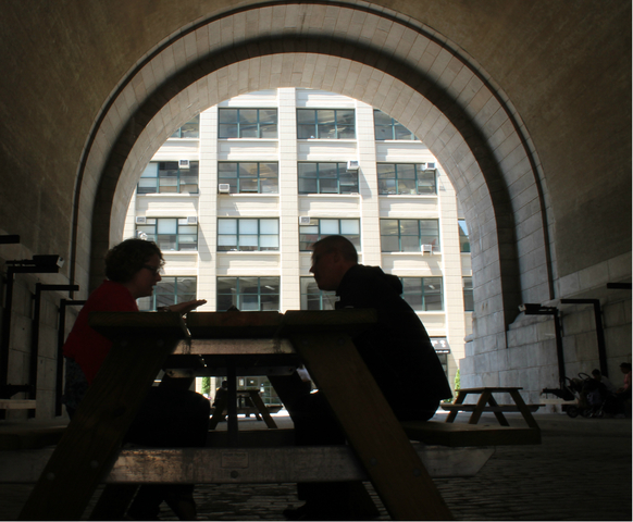 Two people enjoy lunch on the new picnic tables in The Archway.