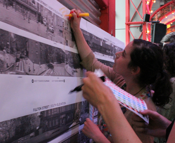 Participants write suggestions for Fulton Street on the wall. 