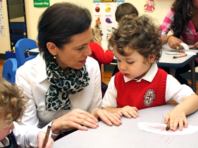 The head of the school, Angela Coombs, talks with an Academy of St. Joseph student.
