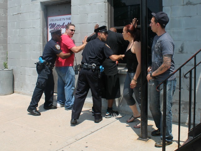<p>Police acting in the first training skit frisk two men whose descriptions match a radio call.</p>
