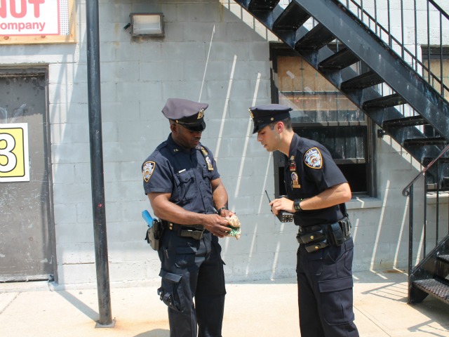 Two police officers acting out a training skit demonstrate the proper procedures during a drug find.