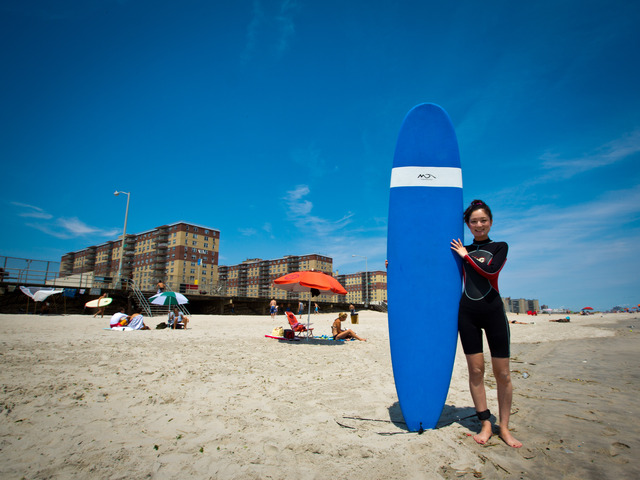 Akemi Tatsuta, 27, from Astoria with her surf board before heading to the beach.