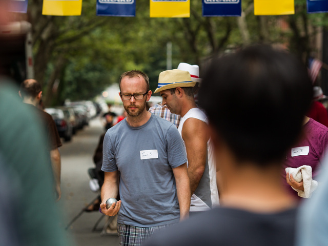 A player lines up his shot during a game of petanque at Bastille Day in Brooklyn on July 15th, 2012.