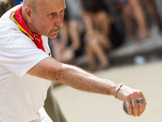 A player prepares his shot during a game of petanque at Bastille Day in Brooklyn.