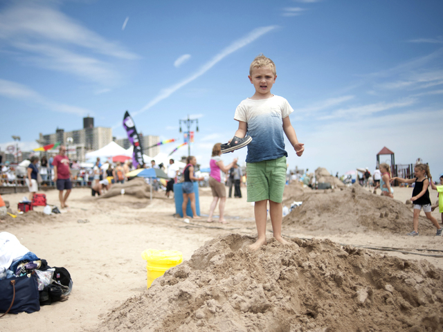 Luka, of Manhattan, stands on a sand pile near his family whose pirate themed sculpture took 1st place in the mixed kids and adults division on July 21, 2012.   