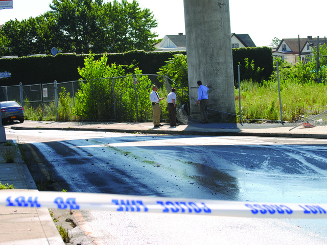 Detectives look over the scene July 22, 2012.
