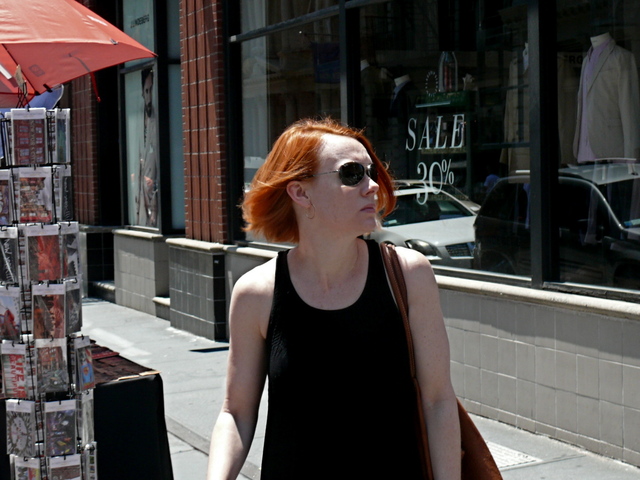 Titian coped locks look smashing with jet black aviators and a loose textured knit tunic  and black shorts in SoHo.