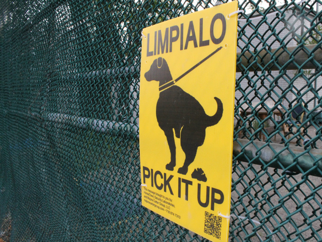 A "Limpialo/Pick It Up" sign attached to the fence surrounding the Spofford Avenue detention center. 