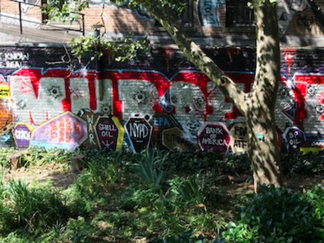 Alan Ket's mural, which included the word "murderers" painted above several tombstones and coffins with epitaph names that included the NYPD, the Environmental Protection Agency and global corporations including Halliburton and Monsanto, was painted on the wall of the business with the permission of its owners.