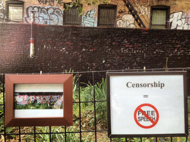 A framed image of the mural before it was painted was affixed next to a sign taht reads 