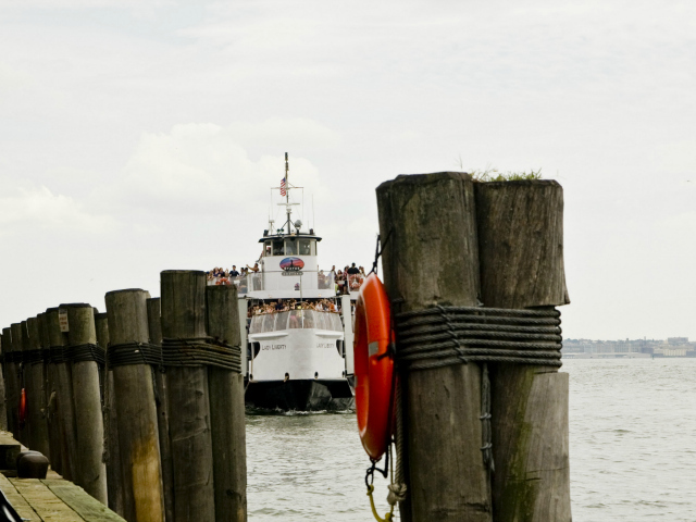 A ferry of visitors approaches Ellis Island. 