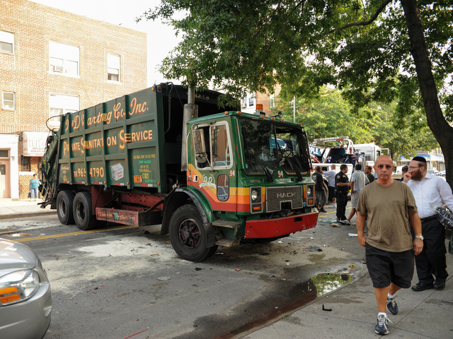 This garbage truck was knocked onto its side by a Jeep SUV early Wednesday morning, Aug. 8, 2012.
