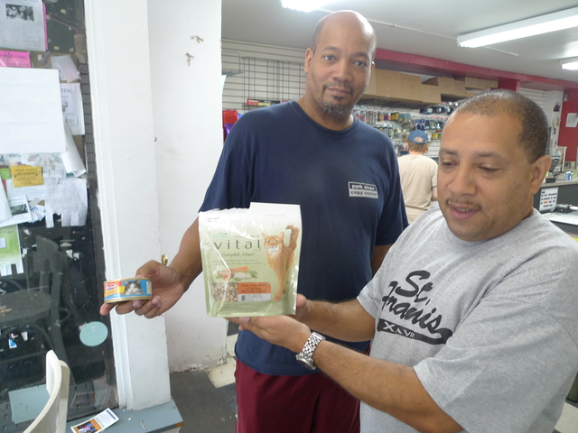 Park Slope Copy Center's Darius Sickles and Alfonso Maldonado with the special soft food they feed their store cats, who have bad teeth.