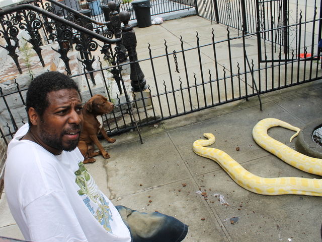Clifton Smith sat with his pit bull and snake on his stoop.