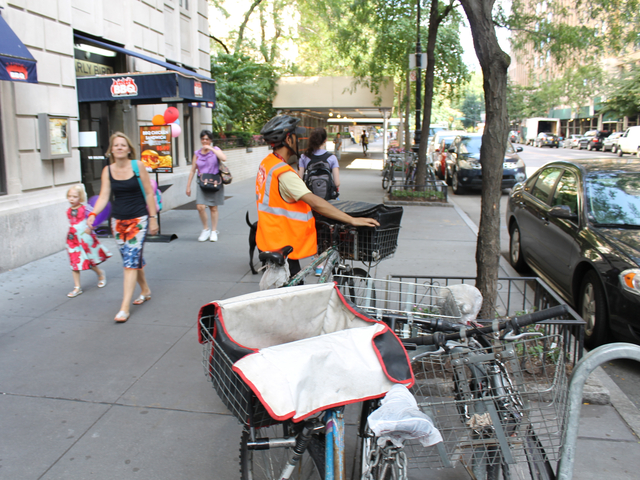 <p>A food-delivery cyclist locks his bike outside the Upper West Side restaurant Dallas BBQ on Aug. 16, 2012. The city will ramp up its enforcement of traffic rules for commercial cyclists in January.</p>
