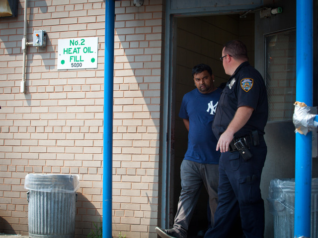 Police walked Mohan Omesh, 29, from the 102nd Precinct in Queens after he was accused of hitting two people on a motorcycle with his Cadillac Escalade Aug. 17, 2012. 