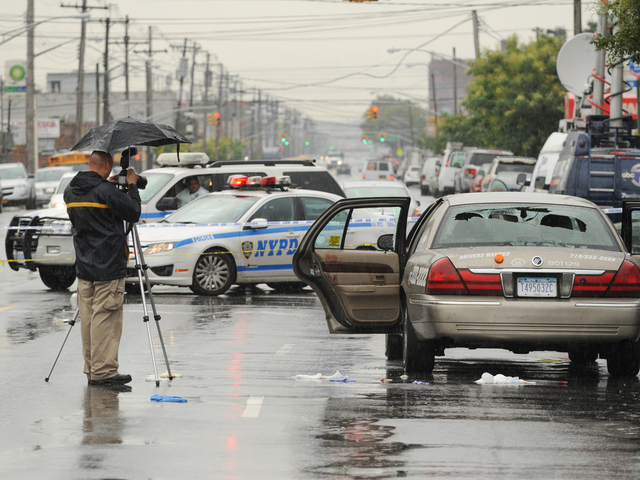 Crime scene officers take photos of the livery cab on Utica Avenue at Avenue M on Saturday Aug. 18, 2012.