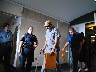 Andrew Douglas covers his face with his hand while he and Anthony Pellegrino, who faced an additional charge of official misconduct, enter court on Monday August 20, 2012. 