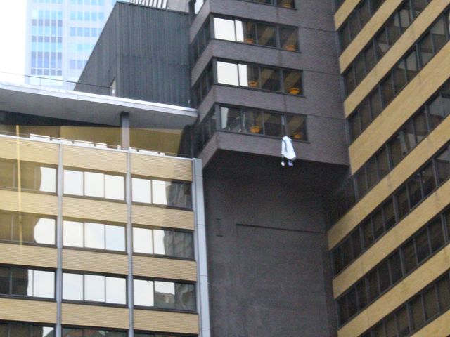 brought in from a window of the Sheraton Hotel in Midtown while protesters chant below. 