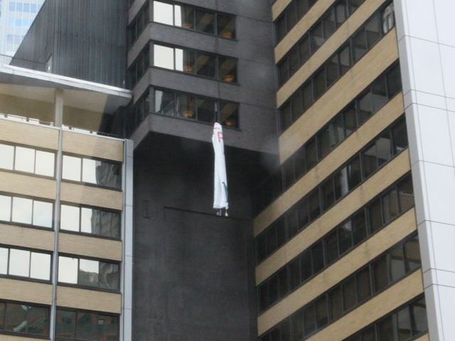 brought in from a window of the Sheraton Hotel in Midtown while protesters chant below. 