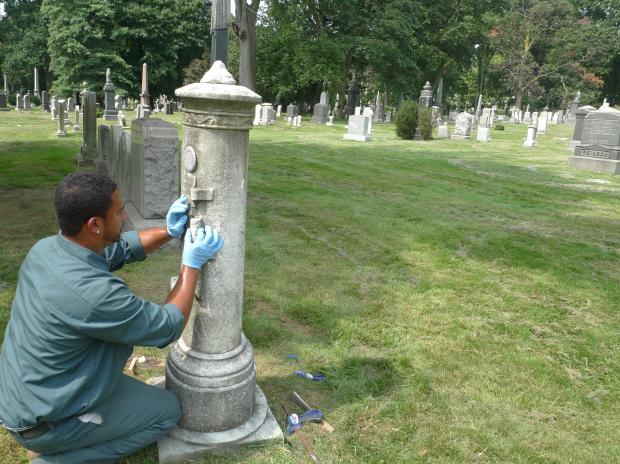 A worker repairs damage at Green-Wood Cemetery after vandals struck the historic cemetery.