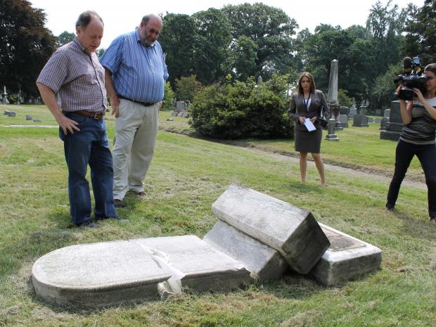Cemetery historian Jeff Richman and Vice President of Operations Ken Taylor show reporters tombstones damaged by vandals at Green-Wood Cemetery in August 2012.