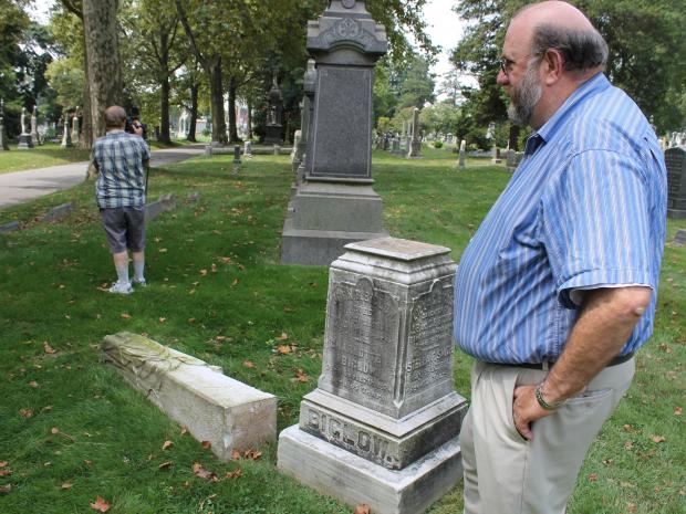 Green-Wood Cemetery's vice president of operations Ken Taylor, at right, shows reporters damaged grave markers.