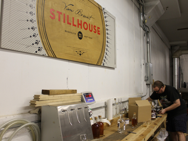 Assistant distiller David Lewis, 36, labels bottles on Due North rum at the Van Brunt Stillhouse. Owner Daric Schlesselman's wife, Sarah Ludington, painted the distillery's signs, Lewis said. 