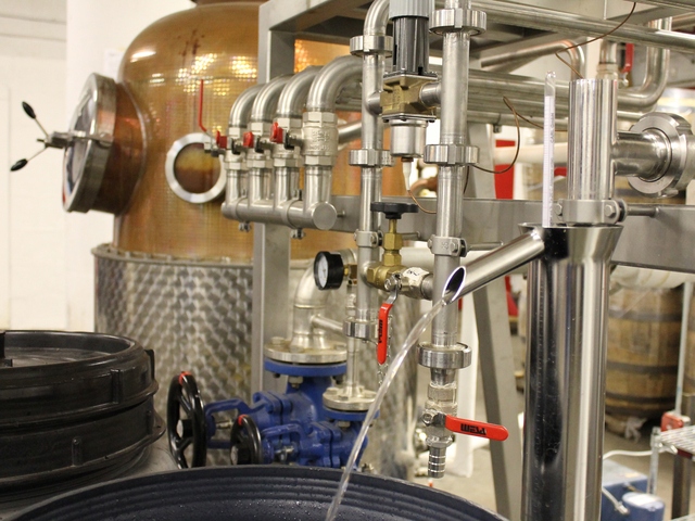 Rum pours from a spigot on Van Brunt Stillhouse's copper still. The spirit, now clear, will be placed in an American oak cask, where it will age and gain its golden color.