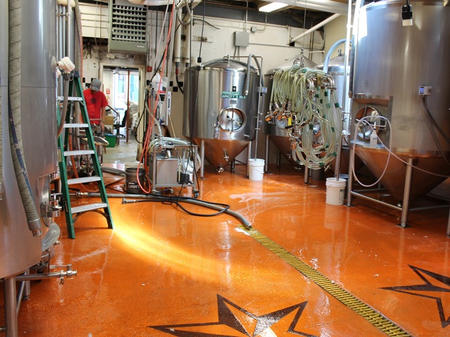 Brewer's assistant Simon Cox, 24, in red at left, prepares to pull yeast from one of Sixpoint Brewery's 465-gallon tanks.